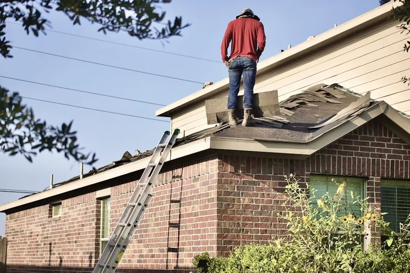 Professional roofer working on a residential roof in Thai Town